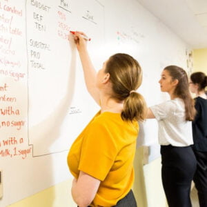 Group of women writing on smart magnetic whiteboard wallpaper wall